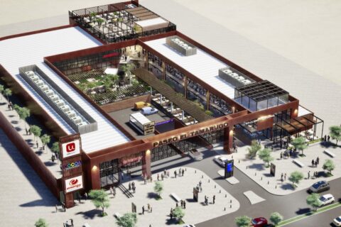 Vista aérea del centro comercial Paseo El Tamarugo, mostrando su arquitectura moderna, áreas verdes, tiendas, zonas de estacionamiento y movimiento de personas en el entorno urbano