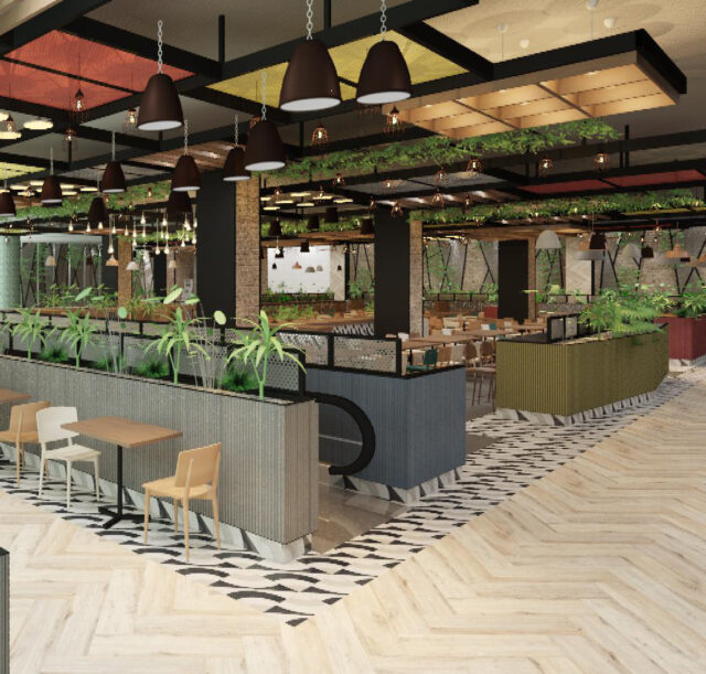 Food court amplio y moderno con mesas, sillas, plantas decorativas y luminarias colgantes, mostrando un diseño contemporáneo con detalles naturales y una escalera mecánica en el centro.