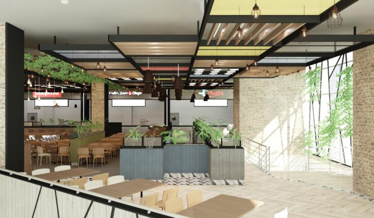Espacio de food court en un centro comercial, con techos decorativos, luminarias colgantes, vegetación interior y mesas de diferentes estilos, junto a locales de comida rápida al fondo.