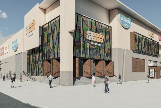 Vista exterior del centro comercial Espacio Urbano Las Rejas, destacando su fachada moderna con paneles de vidrio, detalles geométricos y acceso peatonal amplio, junto a logos de supermercados y tiendas anclas