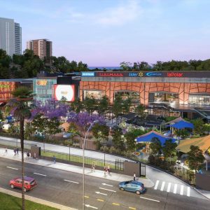 Imagen al atardecer del centro comercial Espacio Urbano 15 Norte, destacando la fachada iluminada, el parque infantil techado en primer plano y los logos de tiendas como Sodimac, Falabella, Cinemark y La Polar.