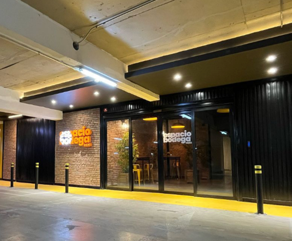 Moderno acceso a mini bodegas, con fachada de ladrillo y detalles industriales en negro y amarillo, ideal para almacenamiento seguro y práctico